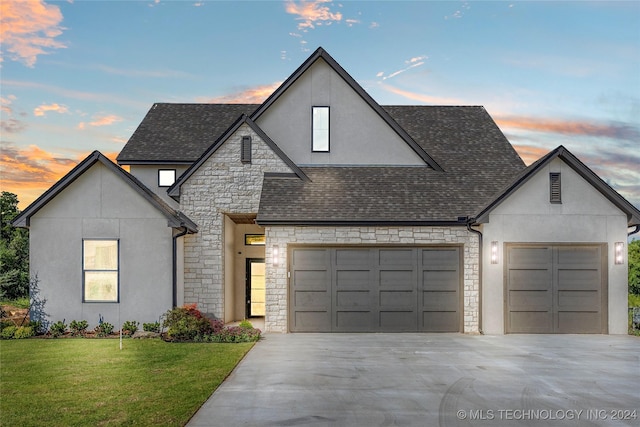 french country home featuring a lawn and a garage