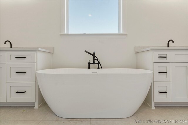 bathroom with tile patterned floors and a tub