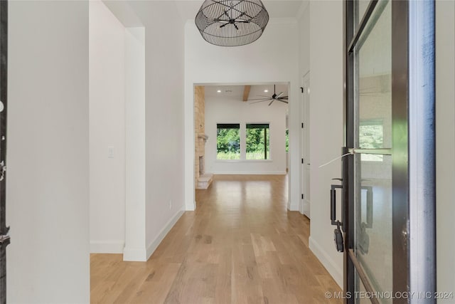 hallway featuring light wood-type flooring and crown molding