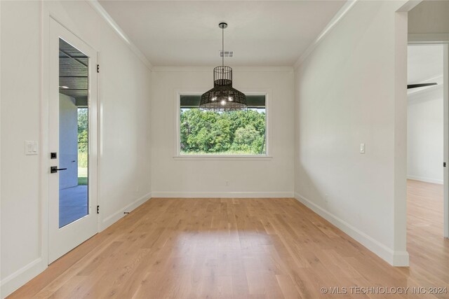 unfurnished dining area featuring crown molding and hardwood / wood-style floors