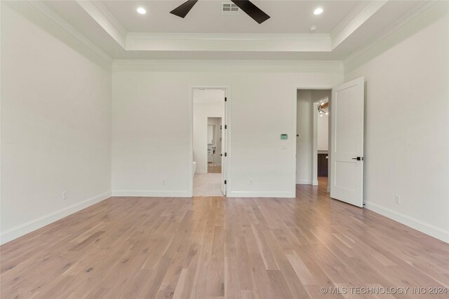 unfurnished room with a tray ceiling, ceiling fan, ornamental molding, and light wood-type flooring