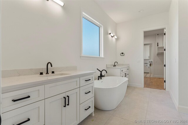 bathroom featuring vanity, tile patterned floors, and a bathtub