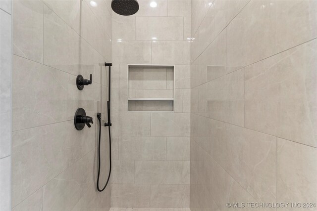 interior details featuring a tile shower