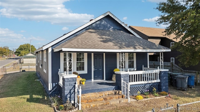 bungalow-style home with covered porch and a front lawn