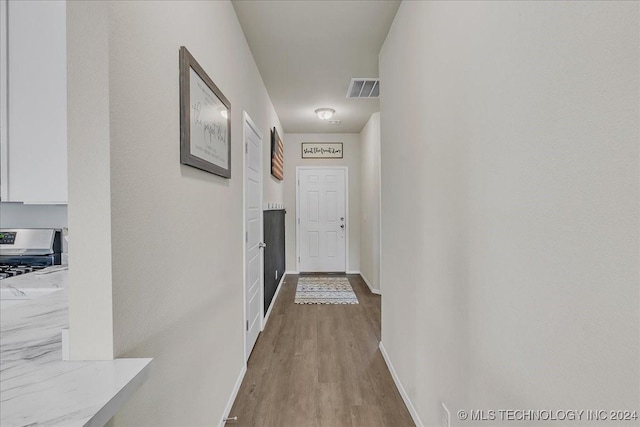 hallway with hardwood / wood-style floors