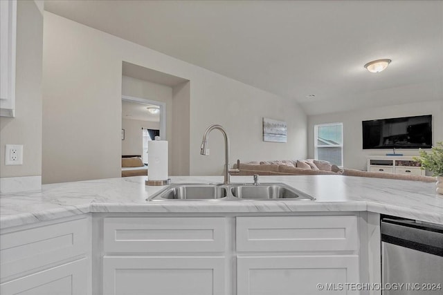 kitchen featuring light stone countertops, sink, and white cabinets