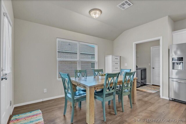 dining area featuring lofted ceiling and light wood-type flooring