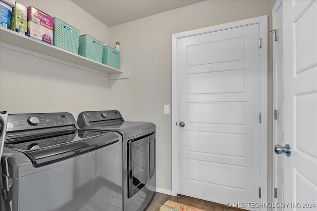 clothes washing area with dark hardwood / wood-style floors and washing machine and clothes dryer