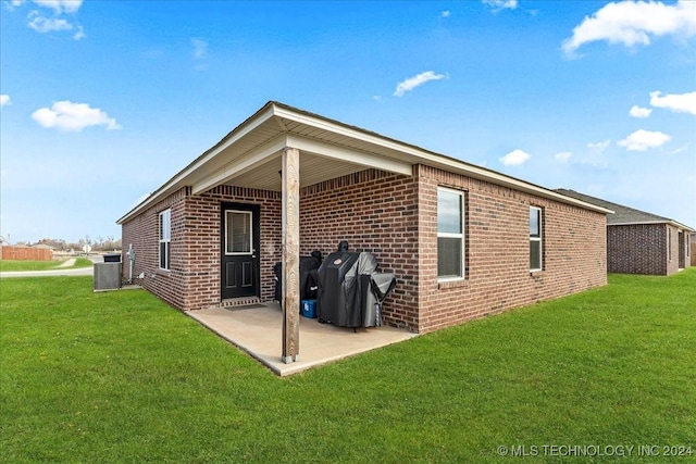 rear view of house with a lawn, a patio area, and central air condition unit