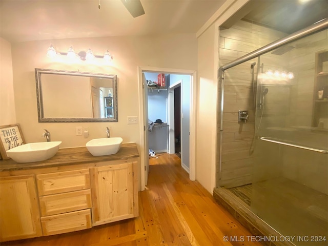 bathroom with hardwood / wood-style flooring, vanity, and an enclosed shower