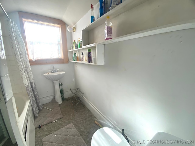 full bathroom with toilet, shower / bath combination with curtain, vaulted ceiling, and sink