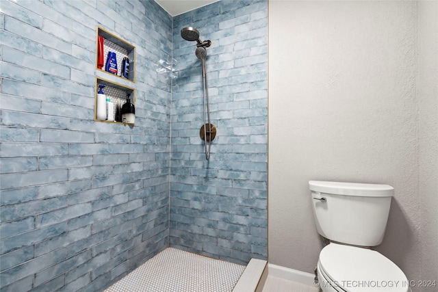 bathroom featuring tiled shower and toilet