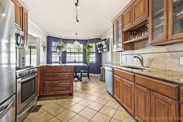 kitchen featuring sink, light stone countertops, light tile patterned floors, decorative light fixtures, and stainless steel appliances