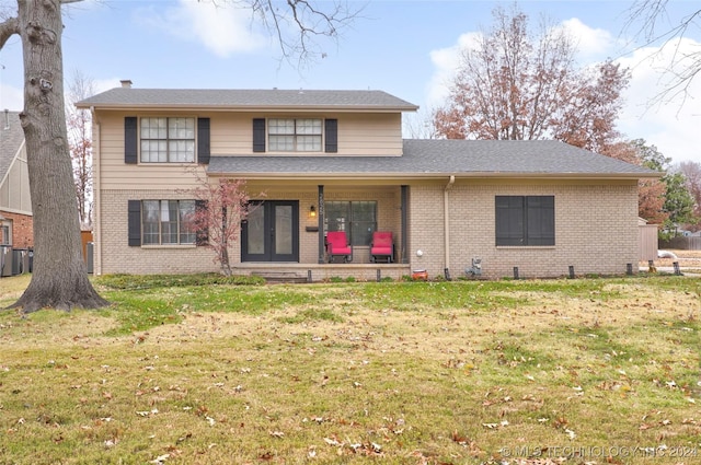 rear view of house with french doors and a lawn