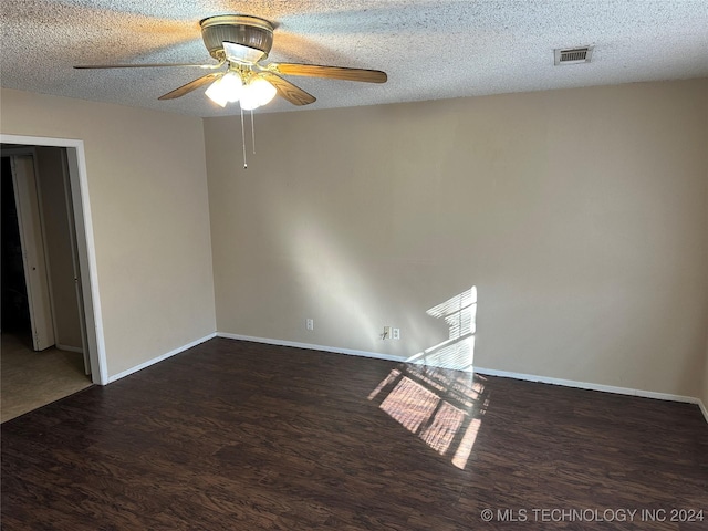 unfurnished room featuring ceiling fan, dark wood-type flooring, and a textured ceiling