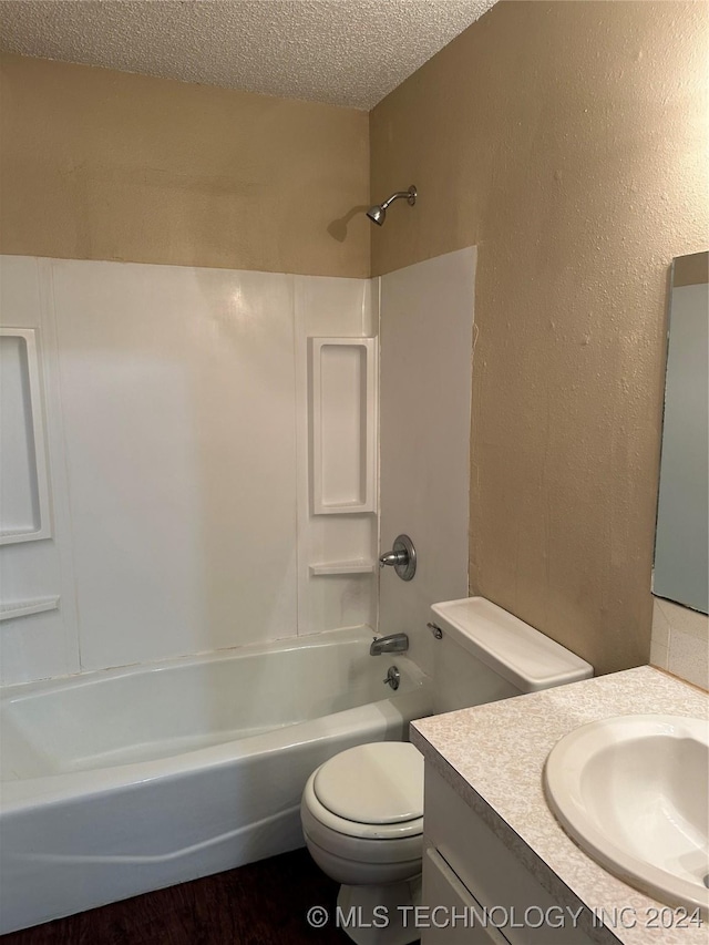 full bathroom featuring shower / tub combination, vanity, a textured ceiling, and toilet