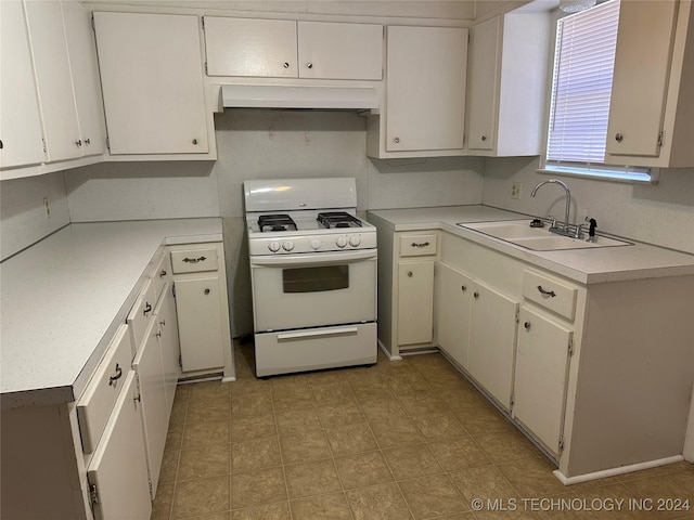 kitchen featuring gas range gas stove, sink, and white cabinets