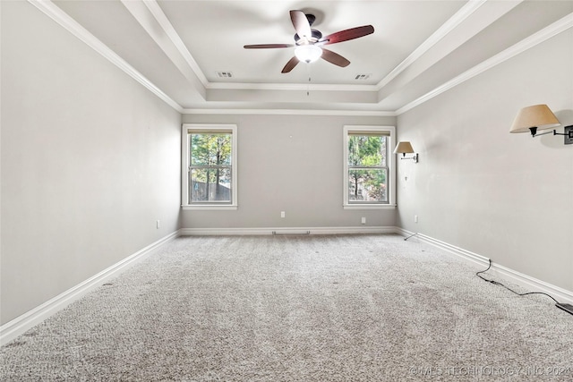 unfurnished room with carpet flooring, ceiling fan, ornamental molding, and a tray ceiling