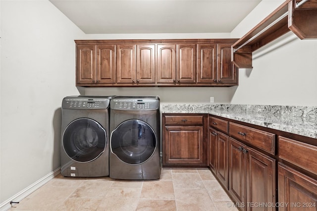 washroom with washer and dryer and cabinets