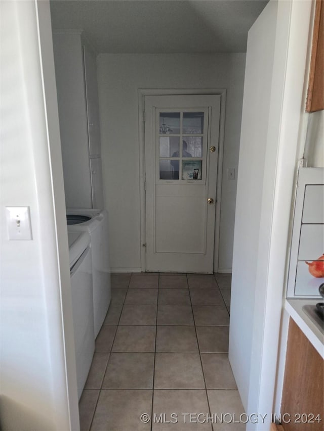 corridor with light tile patterned floors and separate washer and dryer