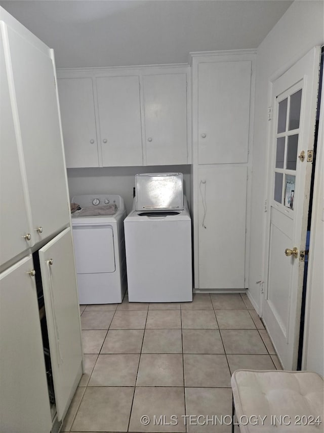 laundry area with cabinets, independent washer and dryer, and light tile patterned floors