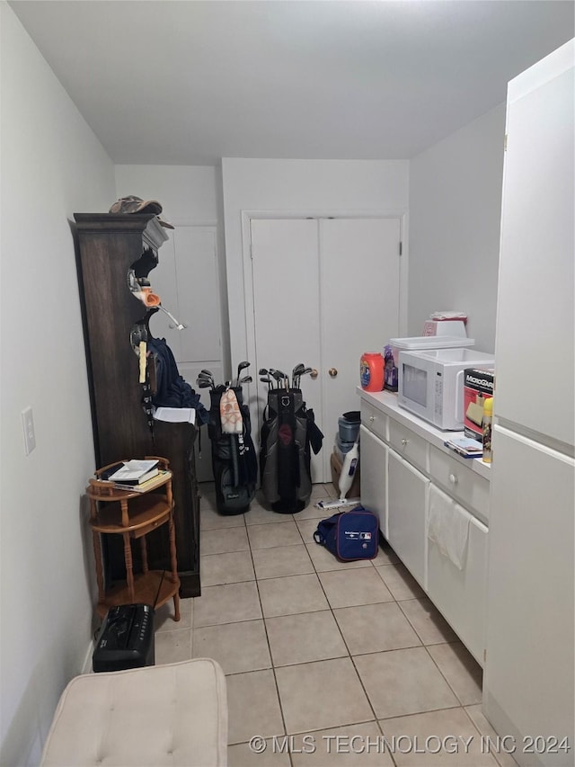 laundry area with light tile patterned floors