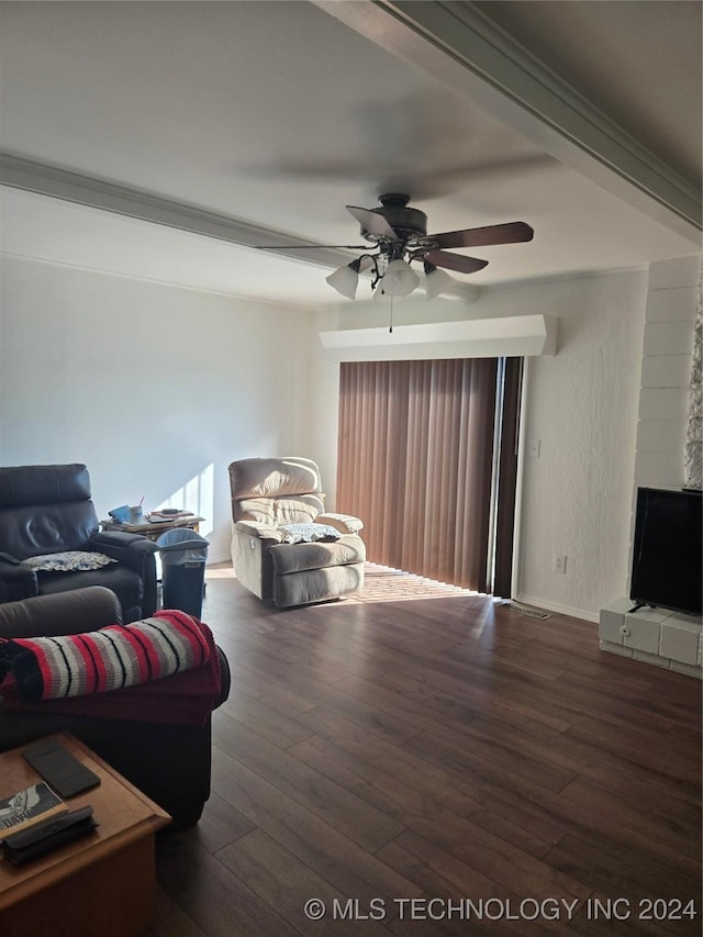 living room featuring dark hardwood / wood-style floors, ceiling fan, crown molding, and a fireplace