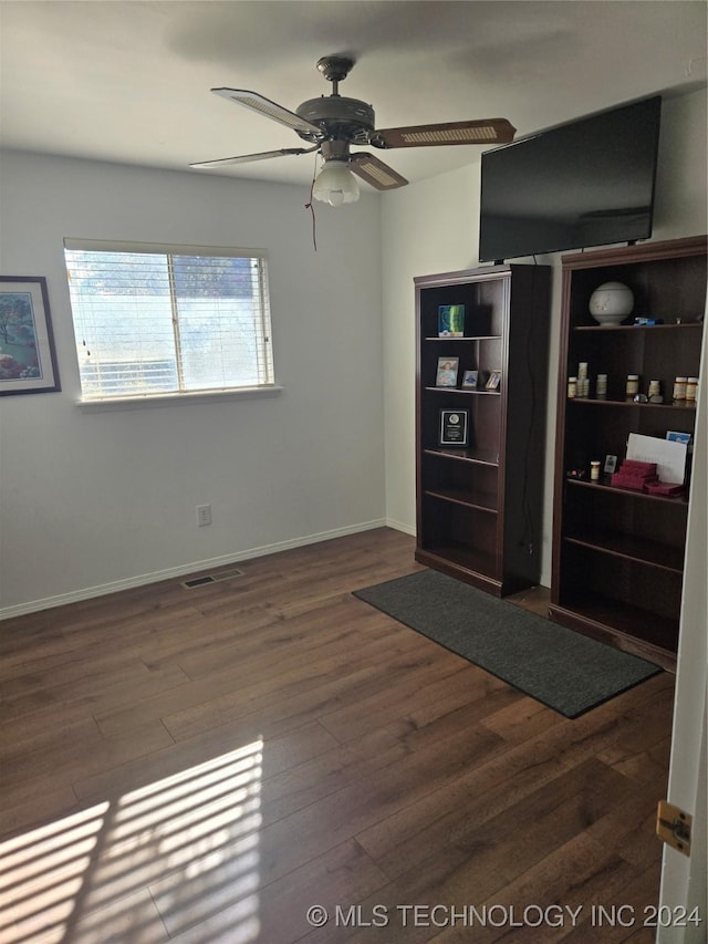 spare room with ceiling fan and dark wood-type flooring