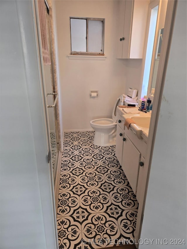 bathroom featuring tile patterned floors, vanity, and toilet