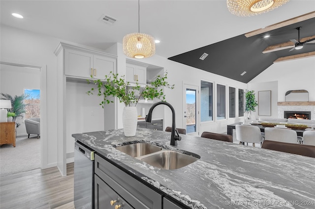 kitchen featuring white cabinetry, dishwasher, sink, ceiling fan, and dark stone counters