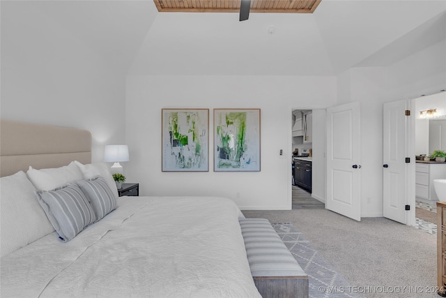 bedroom with ensuite bathroom, baseboards, carpet floors, and high vaulted ceiling