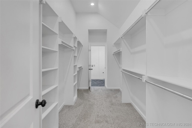 walk in closet featuring light colored carpet and vaulted ceiling