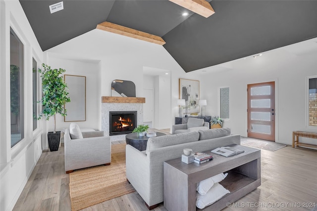 living room featuring lofted ceiling with beams and light hardwood / wood-style flooring