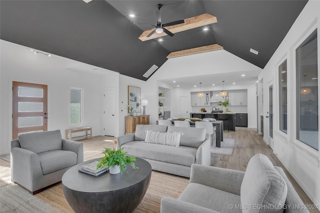 living room featuring built in shelves, ceiling fan, sink, high vaulted ceiling, and light wood-type flooring