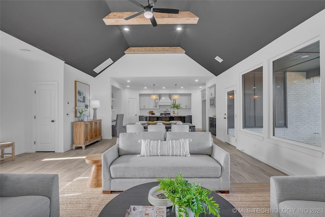 living room featuring built in shelves, light wood-type flooring, high vaulted ceiling, and ceiling fan