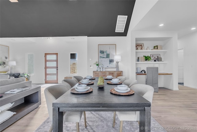 dining area featuring built in features, recessed lighting, and light wood finished floors