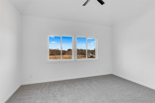 carpeted spare room with a ceiling fan and baseboards