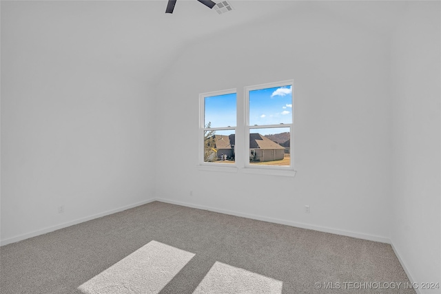 carpeted empty room featuring visible vents, a ceiling fan, lofted ceiling, and baseboards