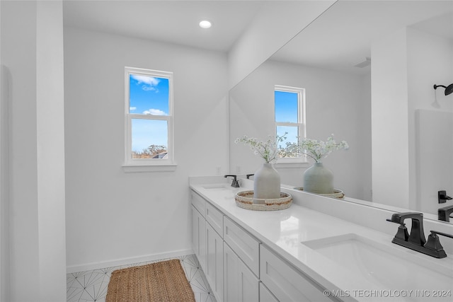 bathroom with tile patterned flooring, vanity, and a healthy amount of sunlight