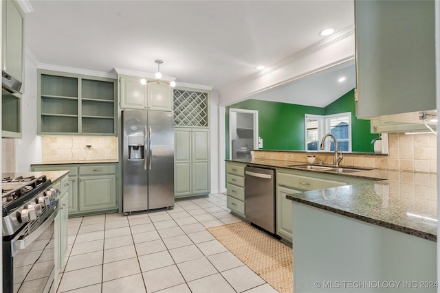 kitchen featuring sink, dark stone countertops, ornamental molding, kitchen peninsula, and stainless steel appliances