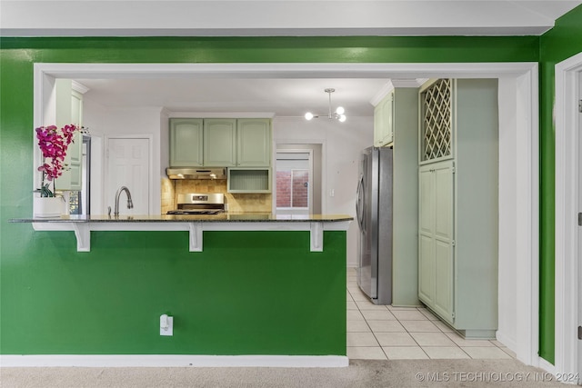 kitchen featuring kitchen peninsula, stainless steel fridge, stove, tasteful backsplash, and light tile patterned floors