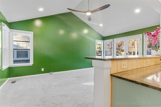 kitchen featuring ceiling fan, dark stone countertops, carpet floors, and high vaulted ceiling