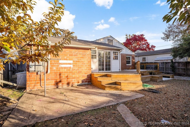 rear view of house featuring a deck and a patio area