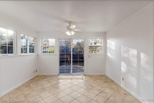 tiled spare room featuring ceiling fan and ornamental molding