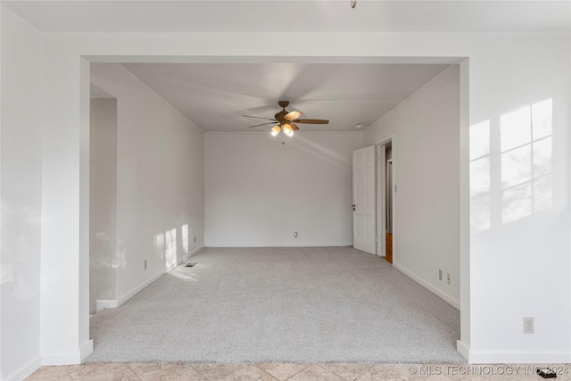 carpeted empty room with ceiling fan, a healthy amount of sunlight, and ornamental molding