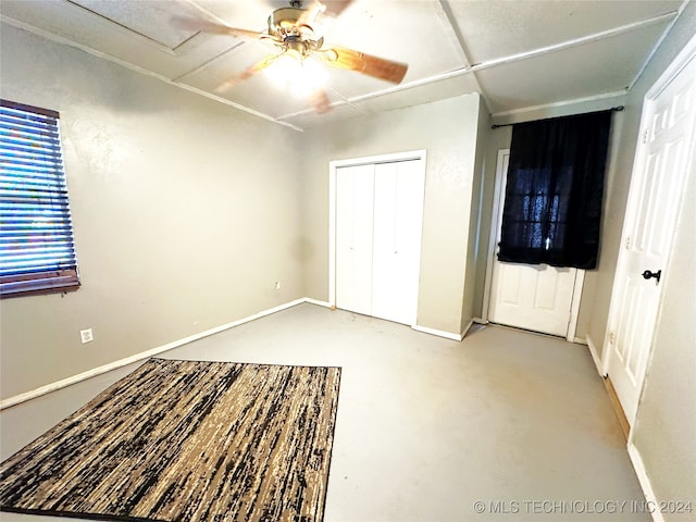 unfurnished bedroom with ceiling fan, a closet, and concrete floors