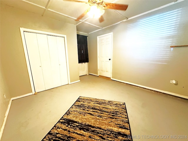 unfurnished bedroom with ceiling fan, a closet, and concrete flooring