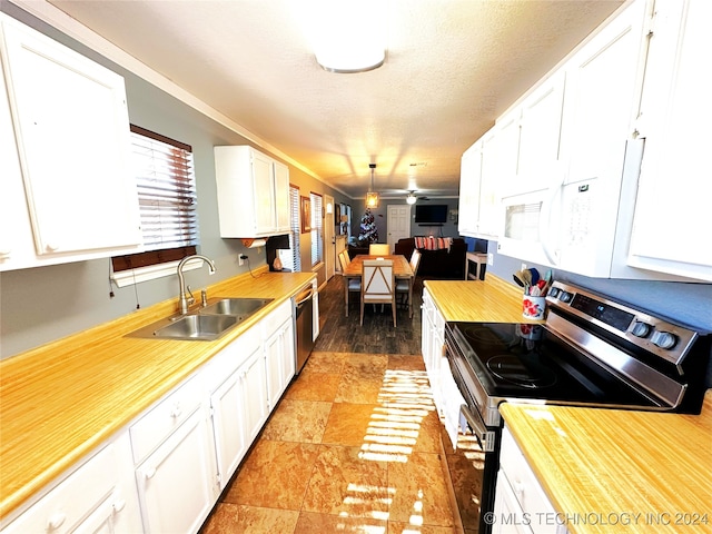 kitchen featuring ceiling fan, sink, stainless steel appliances, a textured ceiling, and white cabinets