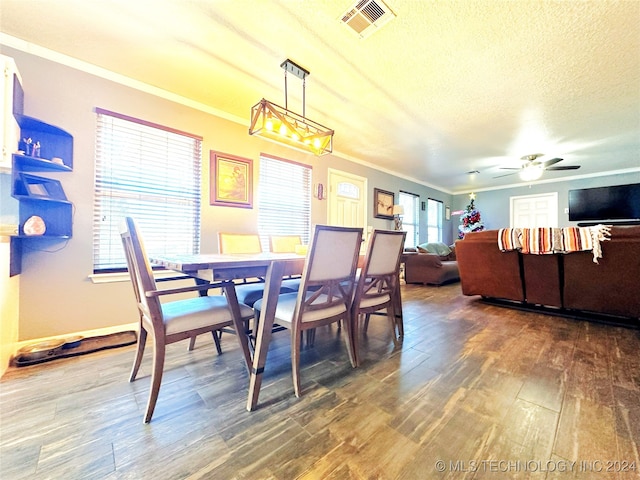 dining space with a textured ceiling, dark hardwood / wood-style floors, ceiling fan, and ornamental molding