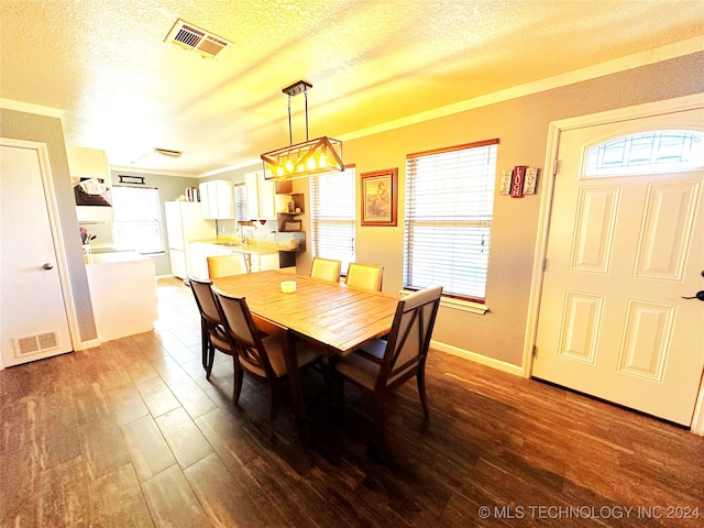 dining area with wood-type flooring and a textured ceiling